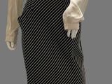 an image of a mannequin wearing a white blouse and black and white striped skirt