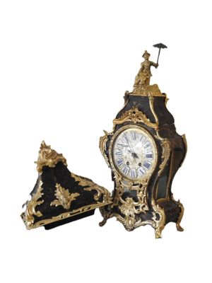 une horloge noire et dorée surmontée d'un drapeau