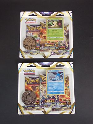 deux paquets de cartes à collectionner Pokémon posés sur une surface noire
