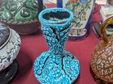 several vases are sitting on a table with a red table cloth