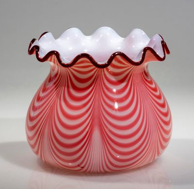 un vase rouge et blanc orné d'un motif ondulé