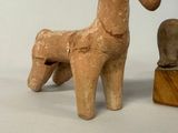 a small wooden horse next to a smaller wooden horse