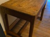 a wooden table with a shelf underneath it in a room