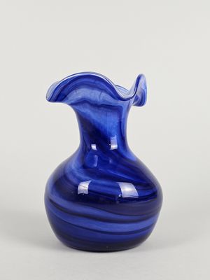 une image représentant un vase en verre bleu sur fond blanc