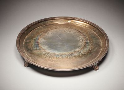 une assiette en argent antique avec un motif circulaire sur le bord