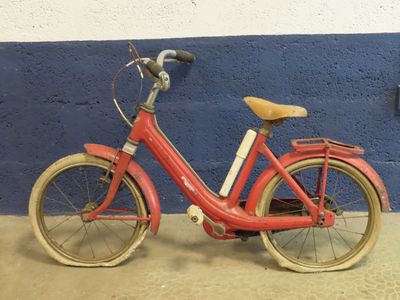 un vélo rouge garé contre un mur bleu