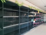 many empty shelves in a store with sodas on them