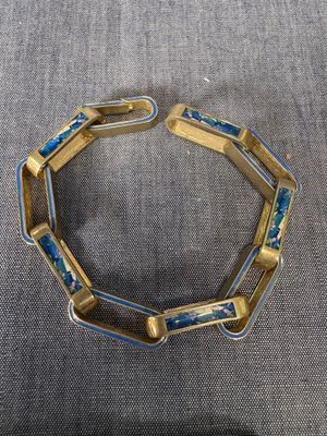 un gros plan sur un bracelet en or orné de perles de verre bleues