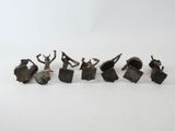 six bronze figurines of people with arms raised in the air