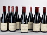 six bouteilles de vin sont alignées sur une table