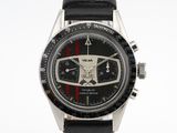 une montre noire ornée d'une bande rouge et blanche