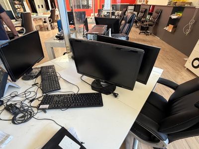 deux écrans d'ordinateur et un clavier sur un bureau