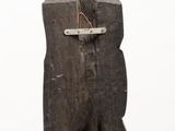 a wooden sculpture of a bear with a tag on it ' s neck