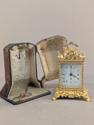 une petite horloge posée à côté d'une boîte ouverte