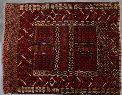 un vieux tapis orné d'un motif rouge