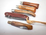 several different types of knives are lined up on a white surface