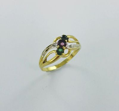 un gros plan d'une bague en or sertie de deux pierres vertes et roses