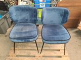 two blue velvet chairs sitting on top of a wooden pallet