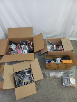Plusieurs cartons contenant divers appareils électroniques sont posés par terre.