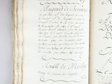 un livre ouvert avec une écriture dessus, posé sur une table