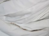 a close up of a bed with a white comforter on it