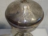 an antique silver plate with a cross on top of it