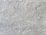 un bloc de pierre sur lequel est gravé un dessin, accroché au mur