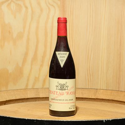 une bouteille de vin posée sur un tonneau en bois
