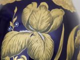 a blue vase with a gold design on it