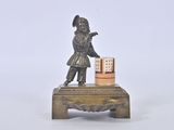 a small statue of a boy with a book on a table