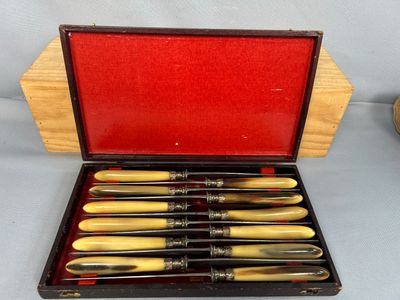 six stylos dans un étui posé sur une table à côté d'une horloge