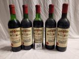 quatre bouteilles de vin sont alignées sur une table
