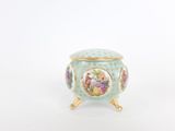 a small blue vase with flowers on it on a stand