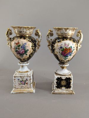 paire de vases anciens ornés de motifs floraux sur un fond gris