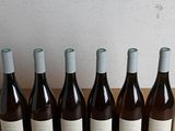 six bottles of wine are lined up in a row on a table