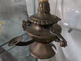 une vitrine en verre sur laquelle sont posés une horloge et une lampe