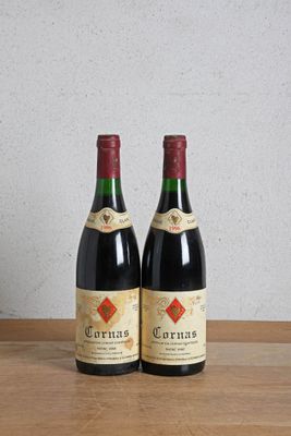 two bottles of wine sitting on a wooden table next to a bottle of wine