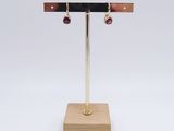 pair of earrings on a stand on a white background