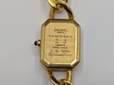 a close up of a watch on a chain on a white surface