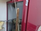 un réfrigérateur rouge dans lequel se trouve une batte de baseball