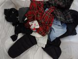 a pile of clothes on a bed with a tag on it