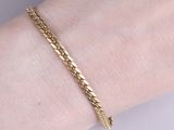 un gros plan sur la main d'une personne portant un bracelet en or