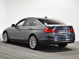 the back of a silver bmw sedan parked in a room