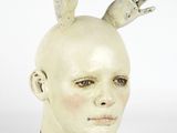 a sculpture of a head with two hands on top of it