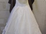 a wedding dress hanging on a hanger in a room