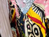 a lot of dresses hanging on a rack in a room