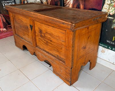 un vieux coffre en bois surmonté d'un miroir