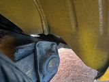 a close up of a yellow car with a black tire
