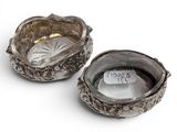 pair of silverplated bowls with handles and handles on a white surface
