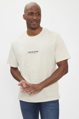 Cet homme porte un t-shirt blanc et un jean bleu.
